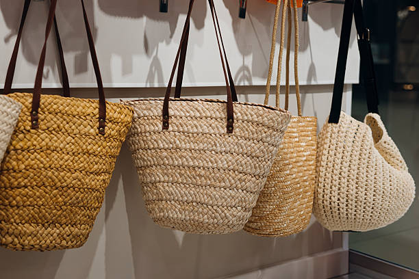 Wicker beach bags displayed in summer boutique shop window.
